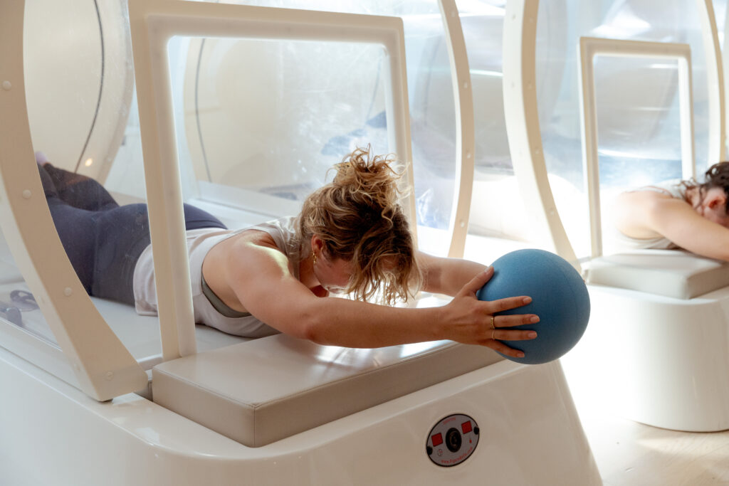 Een vrouw is aan het sporten in een warmtecabine bij bbb health boutique in de Jordaan in Amsterdam. bbb is een holistic gym voor vrouwen