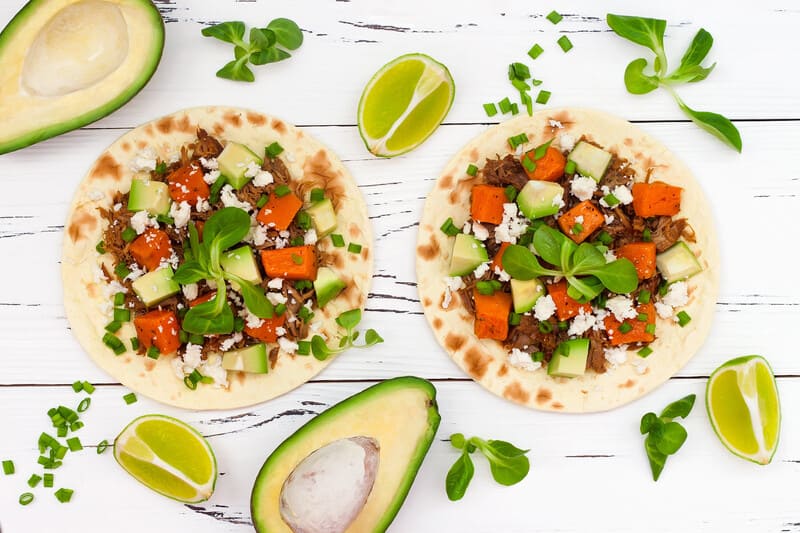 Tortillas with sweet potato, vegetarian minced meat, avocado, and lime.