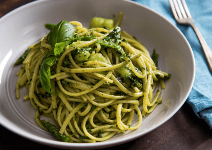 Vegan pasta pesto op een bord met basilicum.  