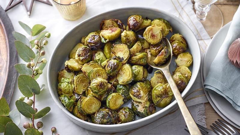 Beautifully presented baking dish with roasted Brussels sprouts.