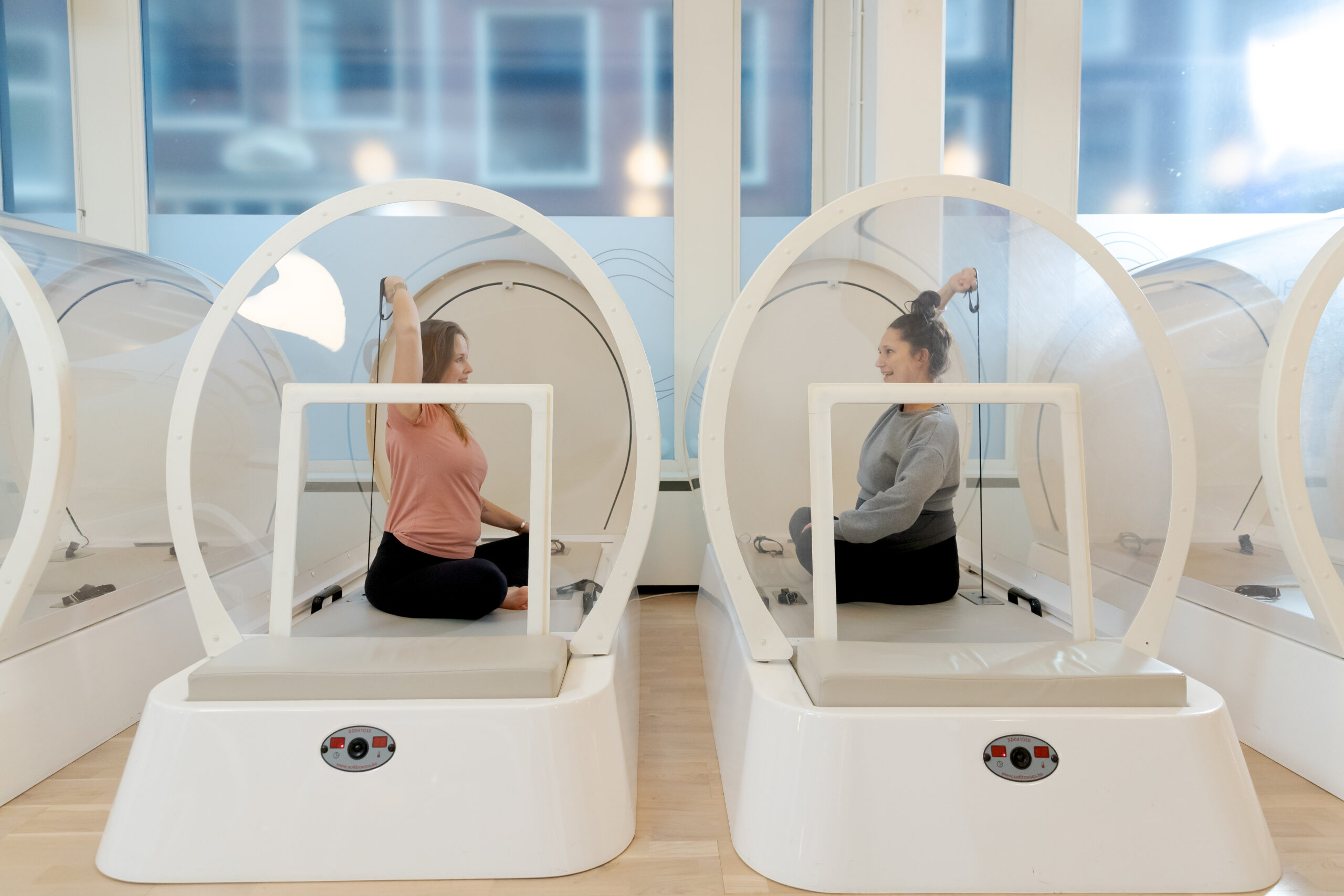 Two pregnant women working out together in a heat cabin at bbb health boutique Amsterdam.