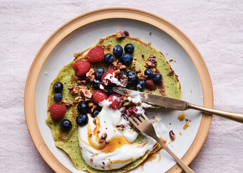 Chickpea pancakes topped with cream and berries