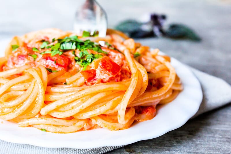 Chickpea pasta with red sauce and tomatoes with garnish. 