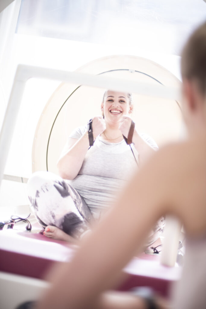 Een vrouw met overgewicht is aan het sporten in een warmtecabine bij bbb health boutique Amsterdam.