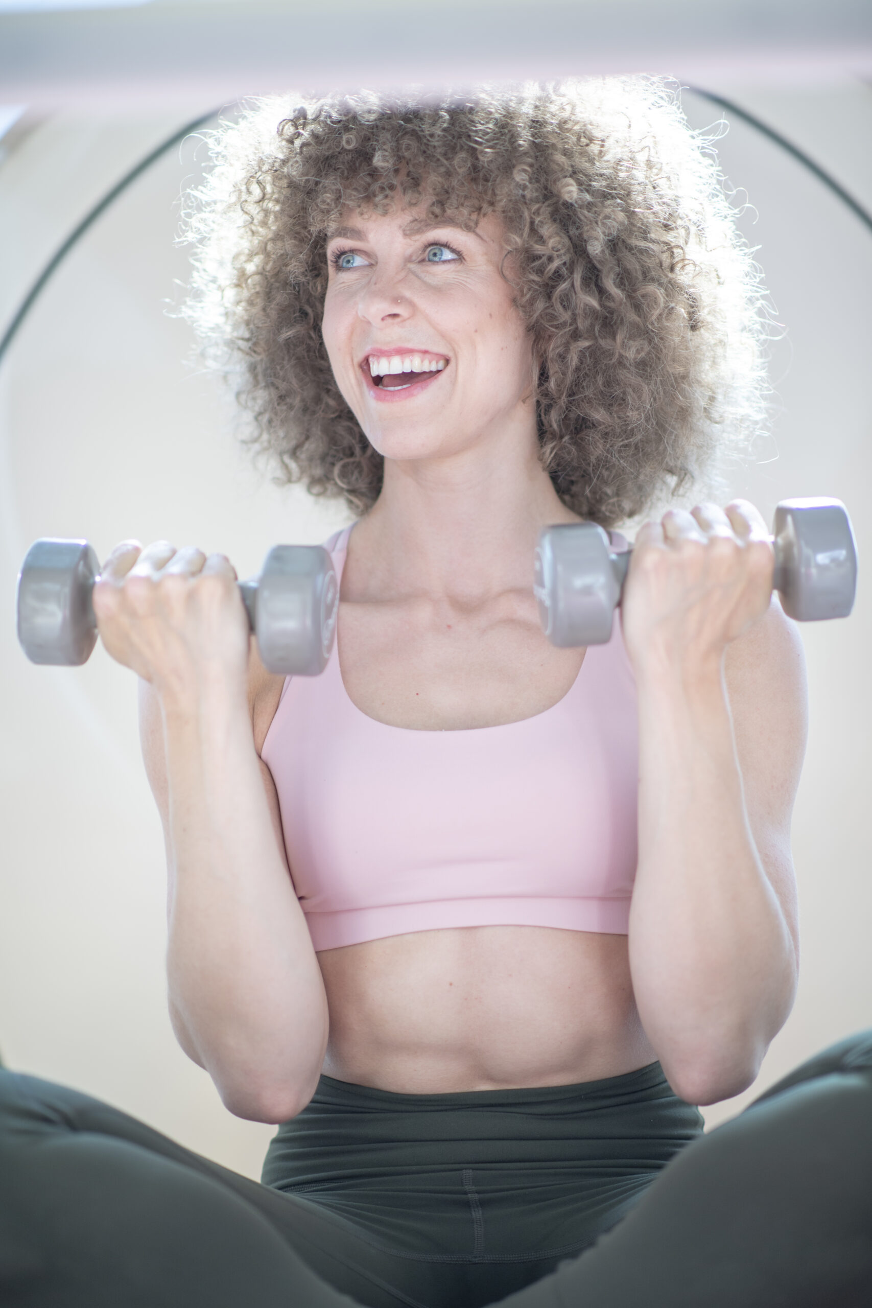 Vrouw traint met een dumbbell in een bbb warmtecabine