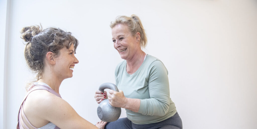 Een vrouw in de menopuze krijgt een kracht workout bij bbb health boutique, een vrouwen gym in Amsterdam.