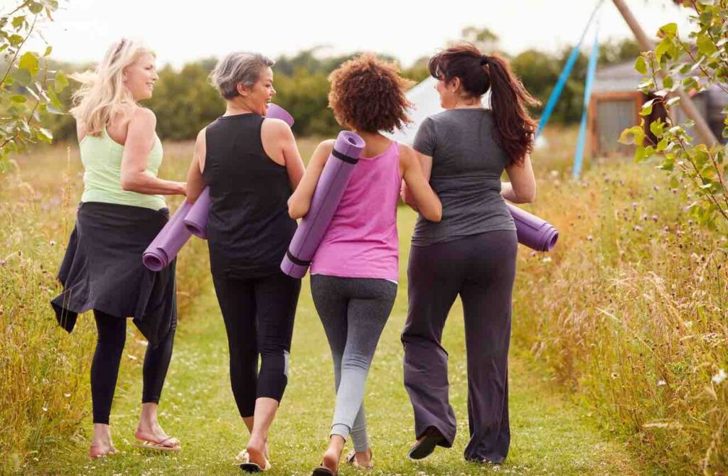 Women walking together outdoors on their way to a yoga class.