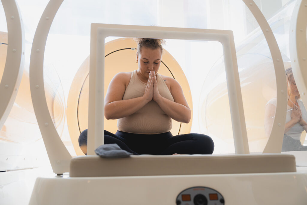 Een vrouw heeft een mindful moment na een workout in de hot cabin bij bbb health boutique in Amsterdam.